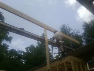 Carpenter setting a ridge beam over a new addition frame — Ice Dam Removal by Roofing Brothers in Claymont