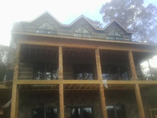 Dormers and porch framing on a large log home under construction — Roof Coating work by our crew in Claymont