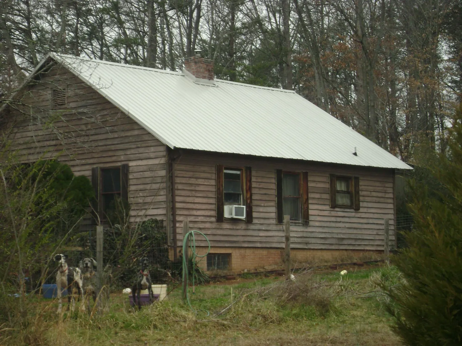 White metal roof on an old wood sided farmhouse, from a Metal Roof Installation job in Claymont